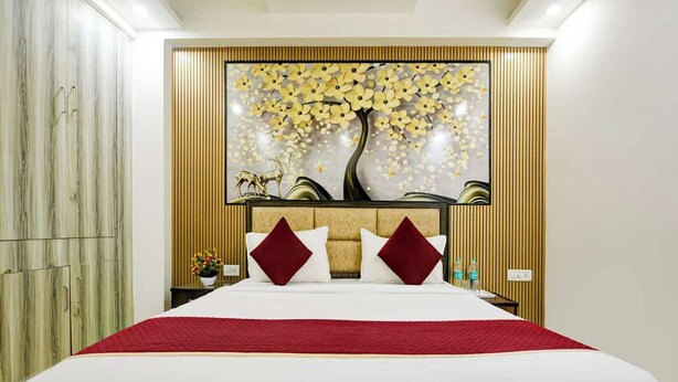 Une chambre d’hôtel moderne avec un grand lit, un panneau décoratif au mur et une armoire.