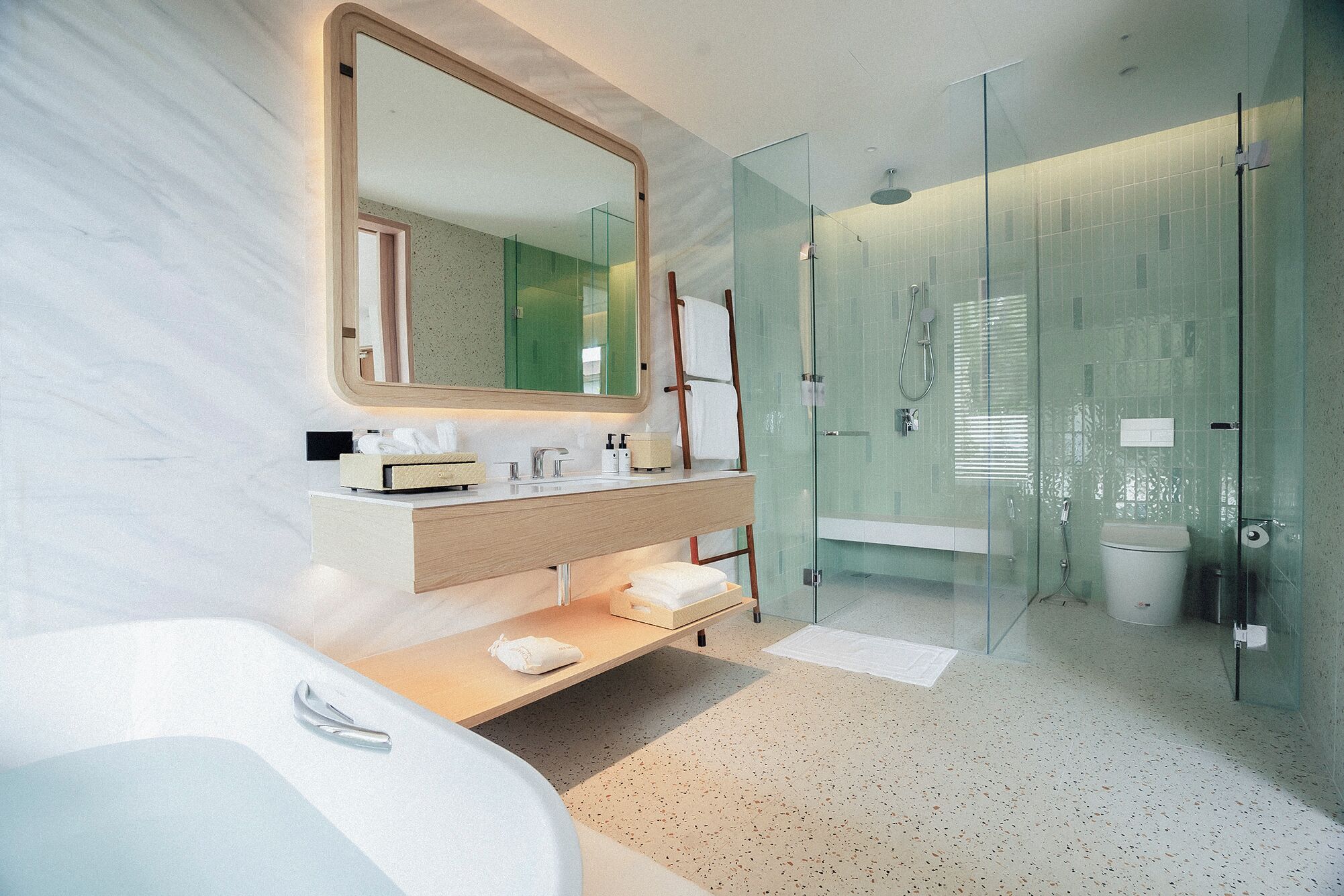 A modern bathroom with a freestanding bathtub, a vanity with a mirror, and a glass-enclosed shower area.