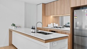 A modern kitchen with a central island, stainless steel appliances, and wooden cabinetry.