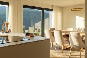Un espace repas moderne avec une grande fenêtre, une table à manger et des chaises.