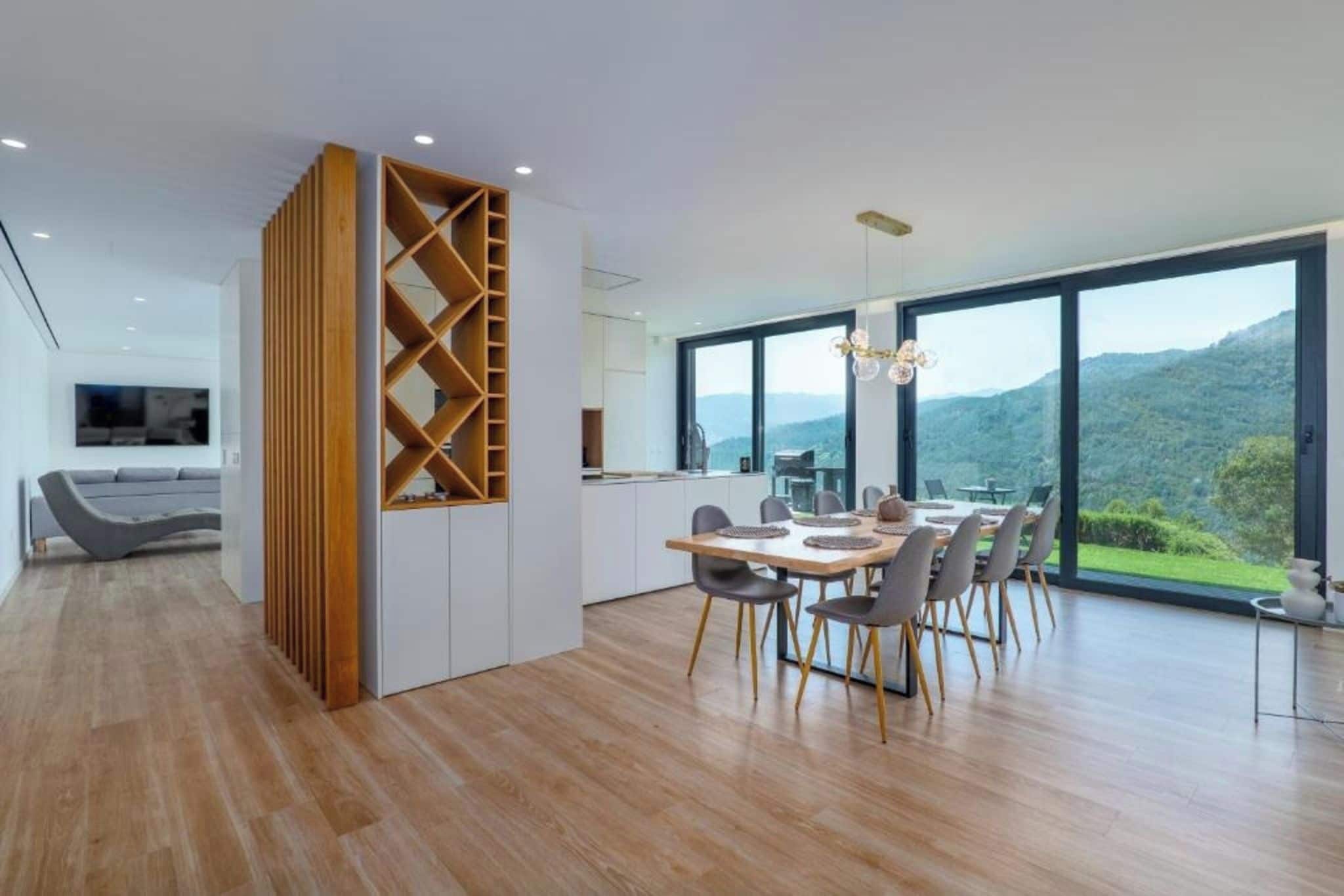 Una cocina moderna con comedor, ventanas amplias y vistas a las colinas.