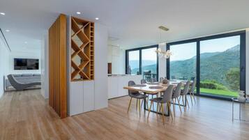 Una cocina moderna con comedor, ventanas amplias y vistas a las colinas.