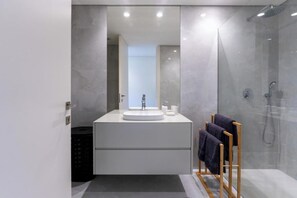 A modern bathroom with a large mirror, a round sink, and a glass-enclosed shower. - Gerês Paradise (Vieira do Minho)