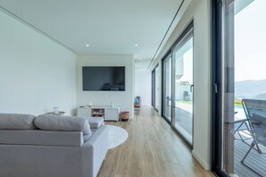A modern living room with a sofa, TV, and a view of the outdoors. - Gerês Paradise (Vieira do Minho)