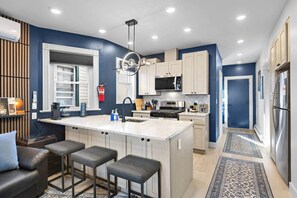 A modern kitchen with a central island, stainless steel appliances, and a built-in microwave. - Modern 3BR/2BA - Easy Walk to NYC Train (Jersey City)