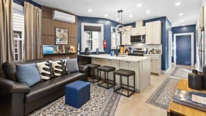 Een modern appartement met een woonkamer, keuken en eethoek.