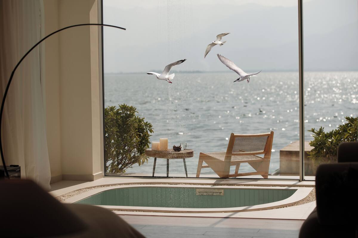Un balcón con vistas al mar, una piscina y una mesa con velas.