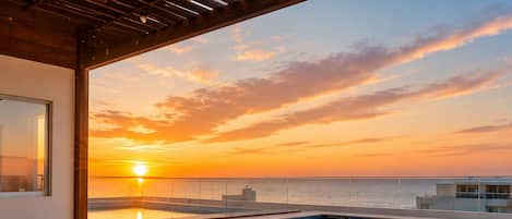 Une piscine sur le toit, avec un jacuzzi, une vue imprenable sur le coucher de soleil et une pergola en bois.