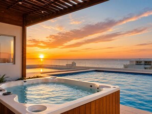 Ein Pool auf dem Dach mit Whirlpool, Blick auf den Sonnenuntergang und einer Holzpergola.
