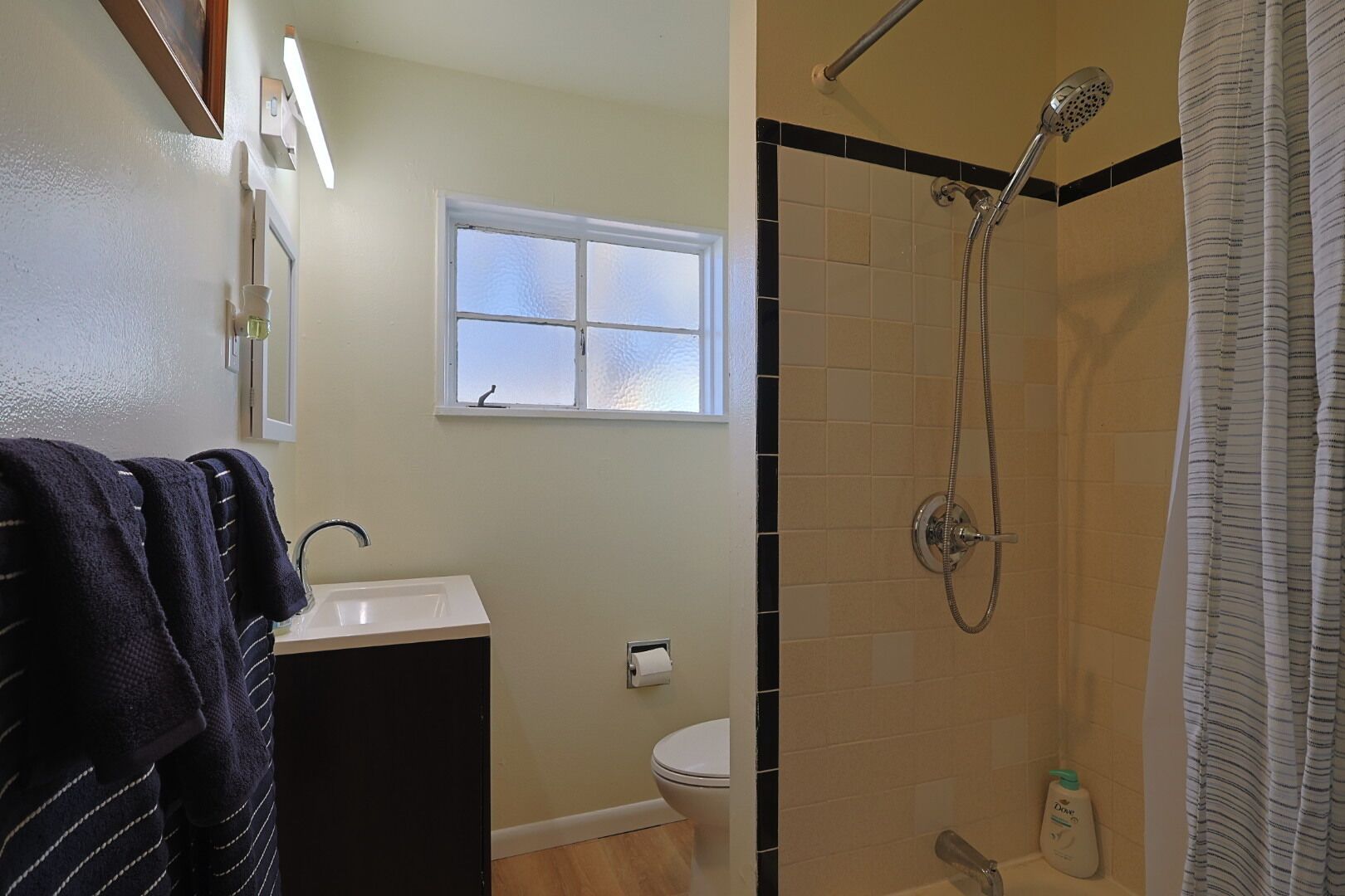 A bathroom with a shower, toilet, and sink.