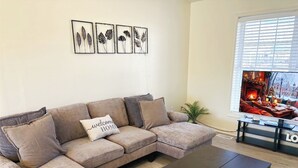Una sala de estar con un sofá modular, una mesa de centro y una chimenea.