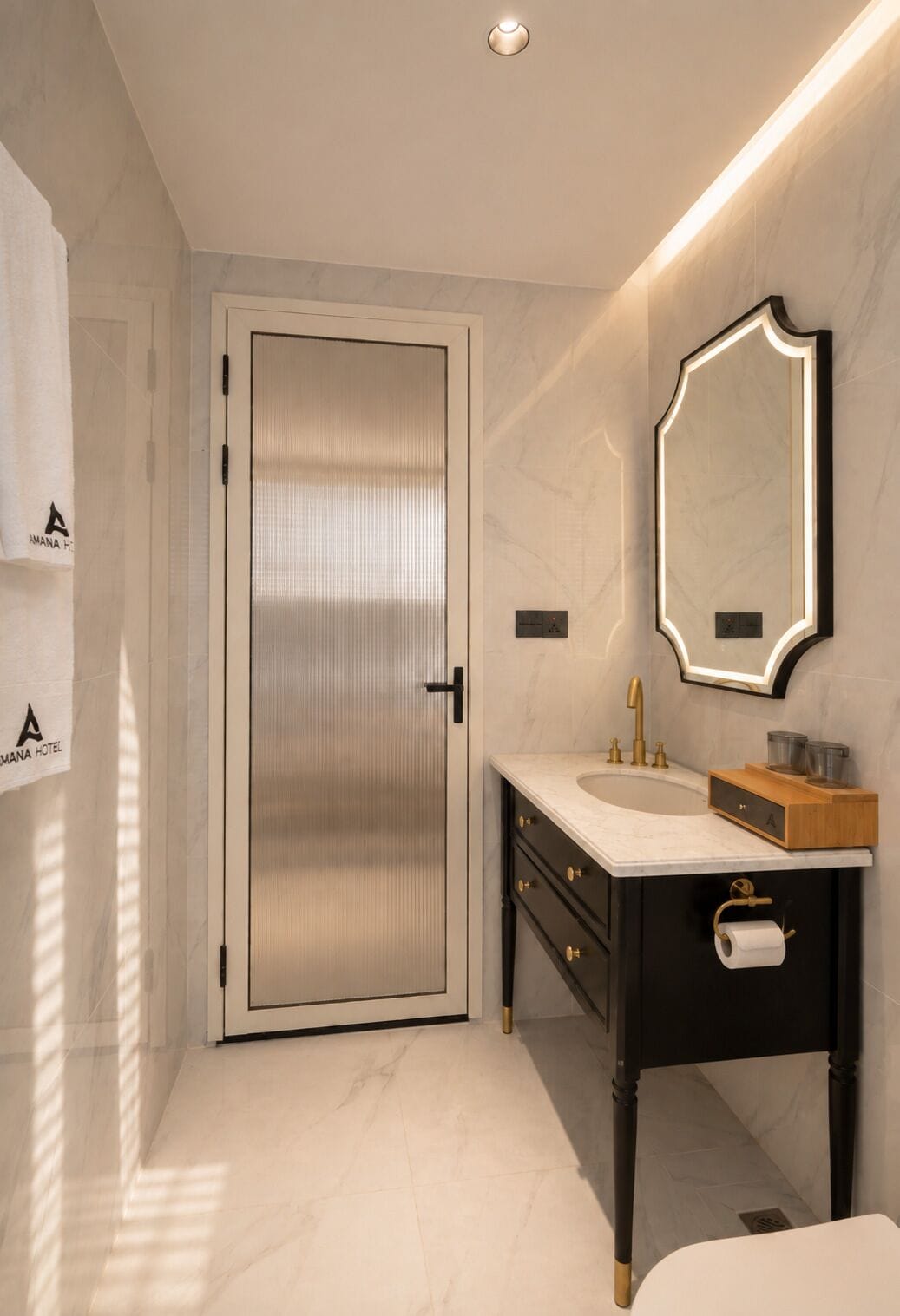A modern bathroom with a marble floor, a white door, a vanity with a mirror, and a towel rack.