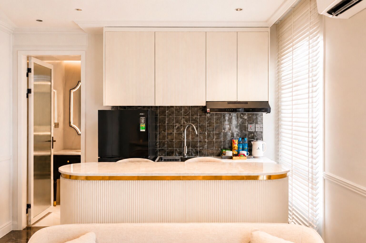 Una cocina moderna con isla integrada, electrodomésticos de acero inoxidable y salpicadero de azulejos negros.