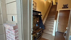 A wooden staircase leading to a second floor, a welcome sign, and a coat rack with a jacket. - Beautiful 3-bedroom townhome with AC in charming Old Mill Area of Bend (Bend)