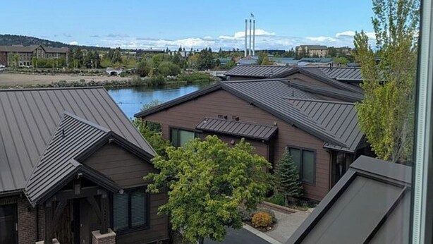 A residential area with modern houses, a river, and a distant power plant. - Beautiful 3-bedroom townhome with AC in charming Old Mill Area of Bend (Bend)