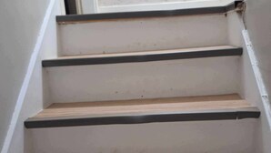 Eine Treppe mit Holzsitzstufen und schwarzen Kanten.