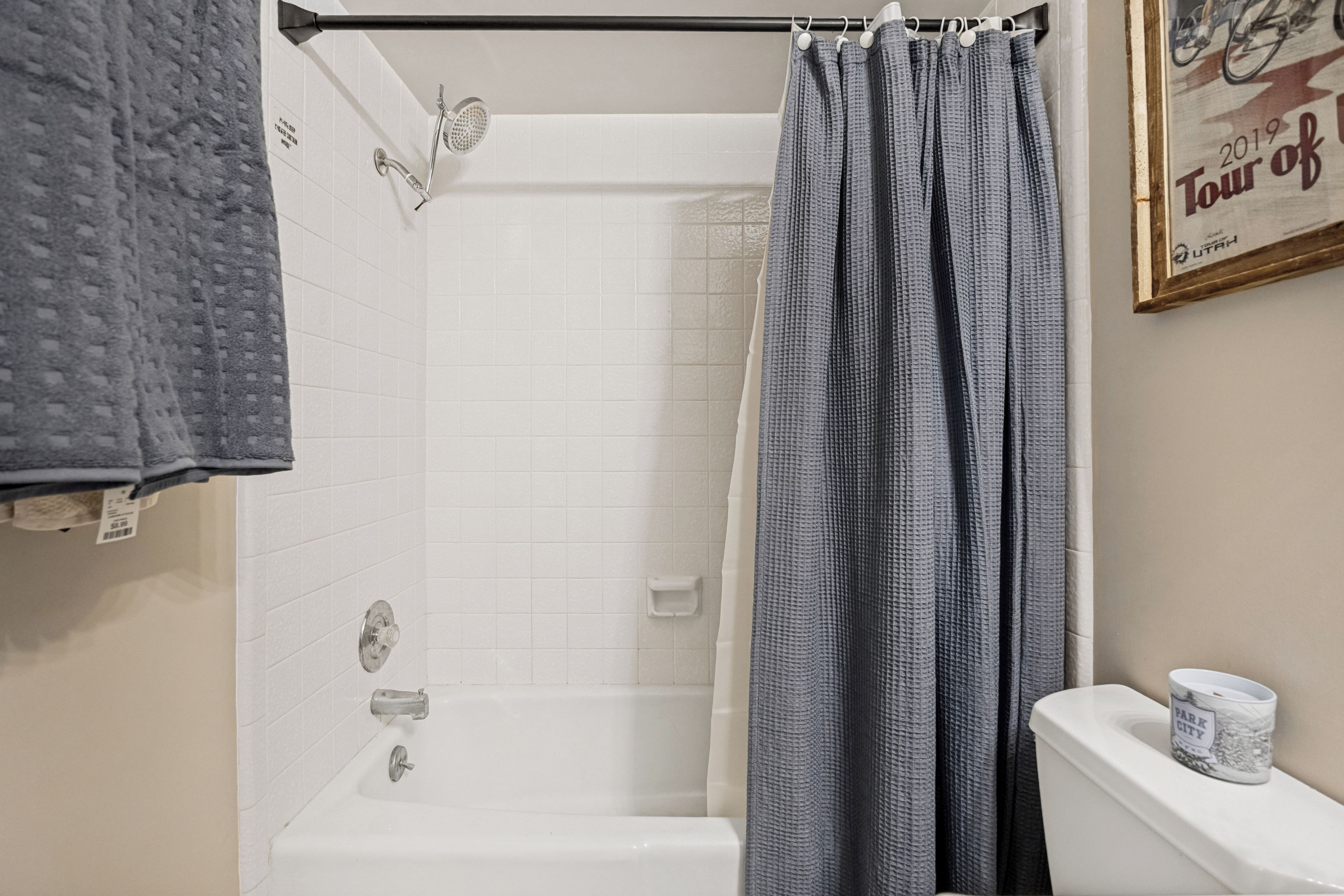 A bathroom with a shower, toilet, and a towel rack.