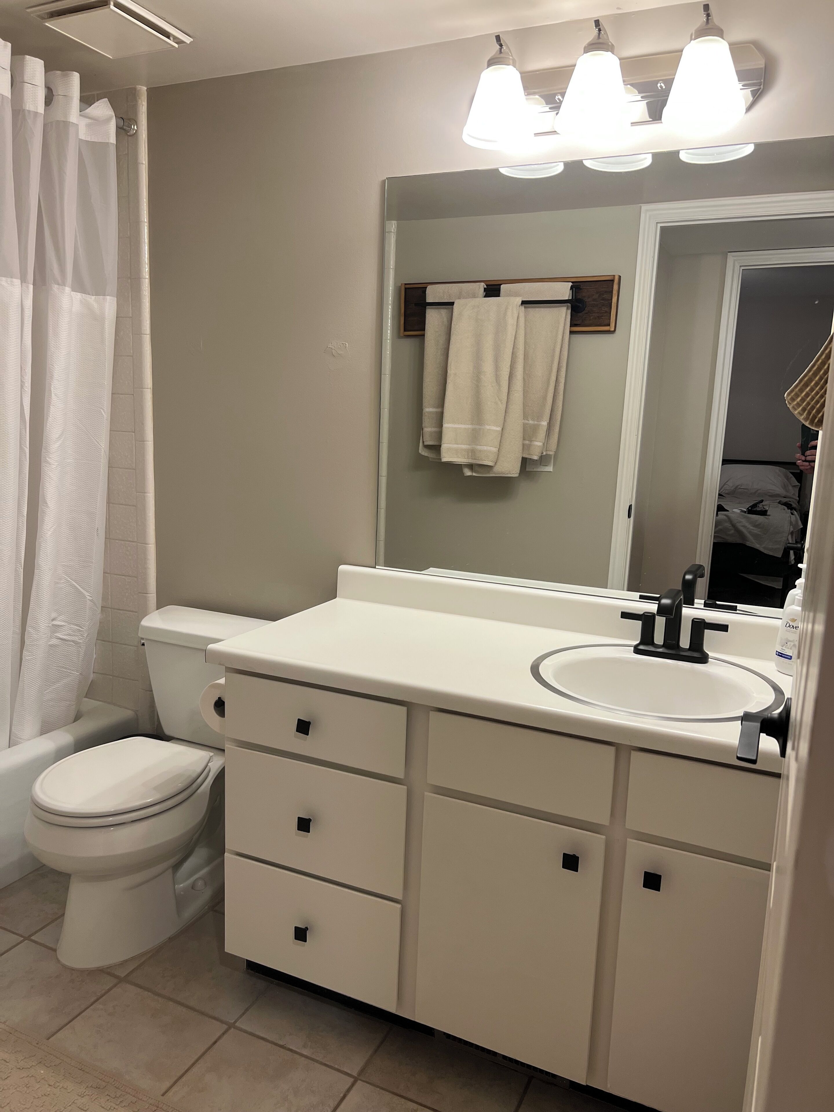 Une salle de bain avec des toilettes, un lavabo et un miroir.
