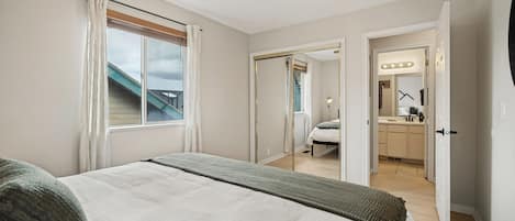Une chambre à coucher avec un lit, un ventilateur de plafond et une vue sur l’extérieur.