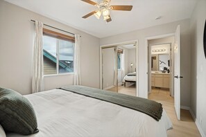Ein Schlafzimmer mit einem Bett, einem Deckenventilator und Blick ins Freie.