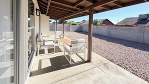 Un patio couvert avec des sièges pour l’extérieur et une vue sur le quartier.