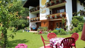 Un hotel con patio giardino, posti a sedere all'aperto e un cartello che indica 'Rauereck'.