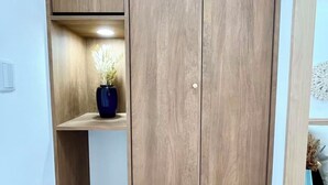 A wooden wardrobe with a shelf and a pair of slippers on the floor. - Raku6 Designer-style Japanese-Western Two-bedroom Ryokan / 15 mins to Shinjuku, (Nakano-ku City)