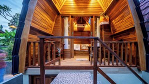 Una cabaña de madera con una escalera que conduce a un porche cubierto.