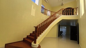 A staircase with wooden balusters and a white handrail leading to an upper floor.