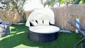 A round outdoor seating area with a white canopy, surrounded by artificial grass and a bamboo fence. - Spacious Luxury Oasis Getaway w/pool 15 mins from beach (Fort Lauderdale)
