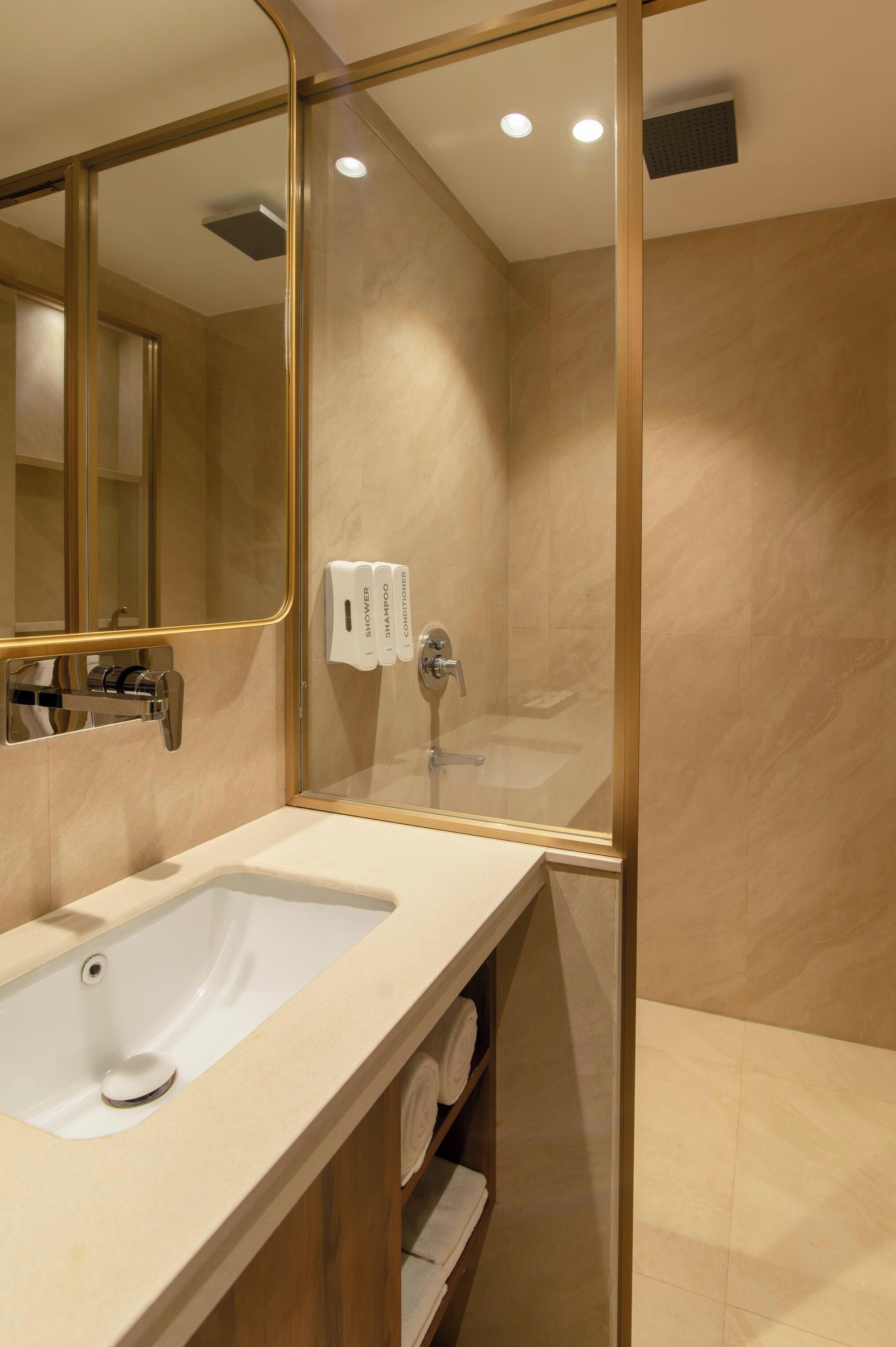 Une salle de bain moderne avec un grand miroir, un lavabo et une douche à l’italienne.