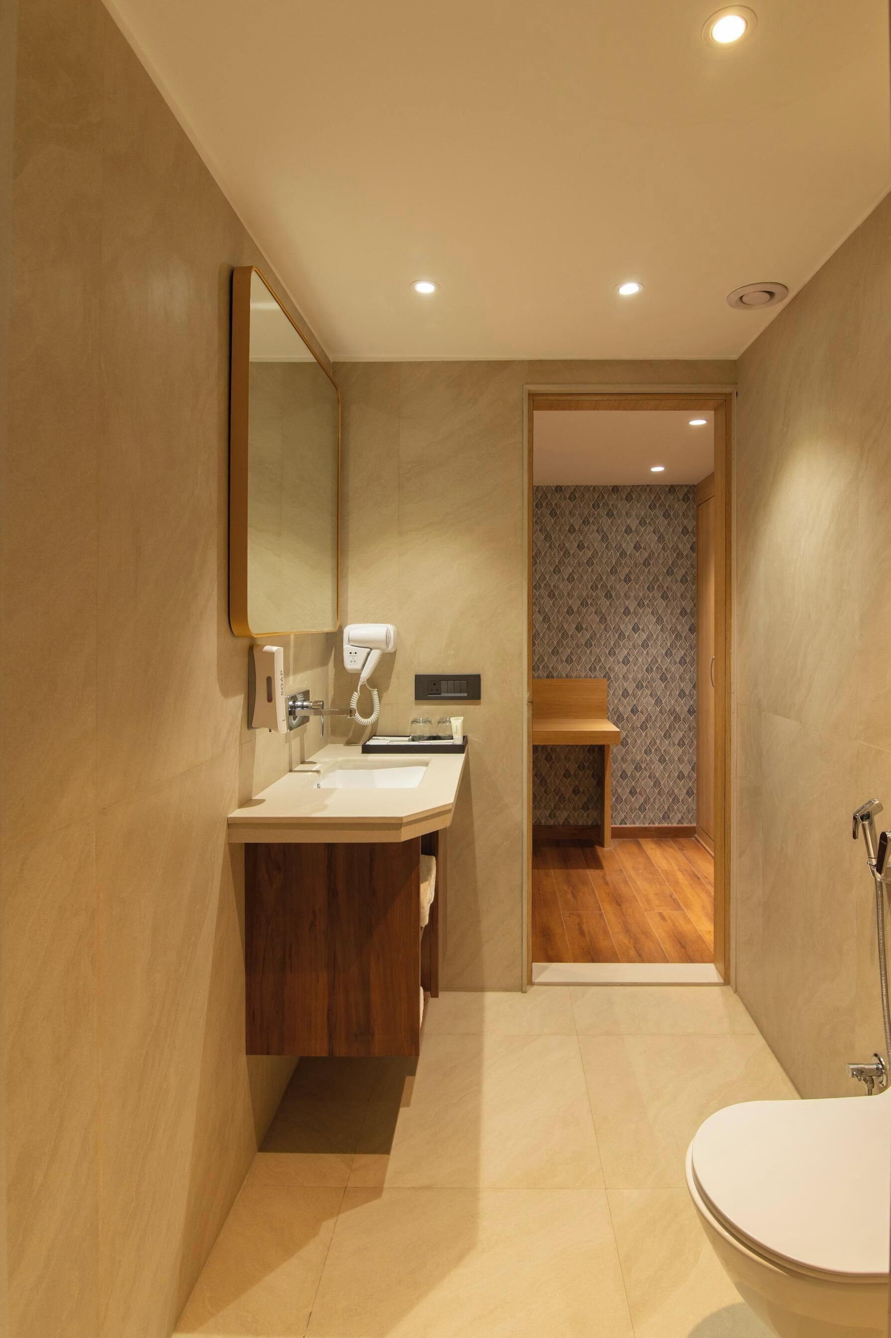 A modern bathroom with a sink, mirror, and toilet.
