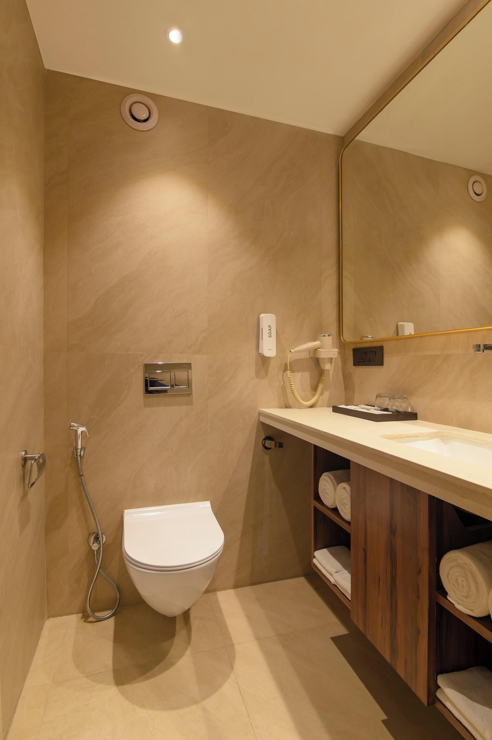 A modern bathroom with a toilet, shower, and vanity.