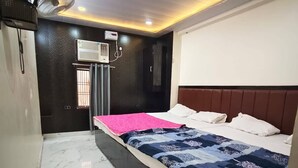 A hotel room with a bed, a wardrobe, an air conditioning unit, and a ceiling fan. - New Jay Radhe Krishan Residency (Varanasi)