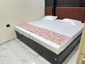 Un lit avec une couvre-lit à motifs, une tête de lit et un sol en marbre.