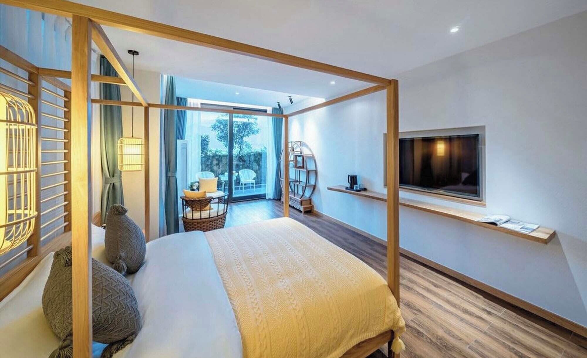 Un dormitorio moderno con cama con dosel, televisión y balcón con vistas.