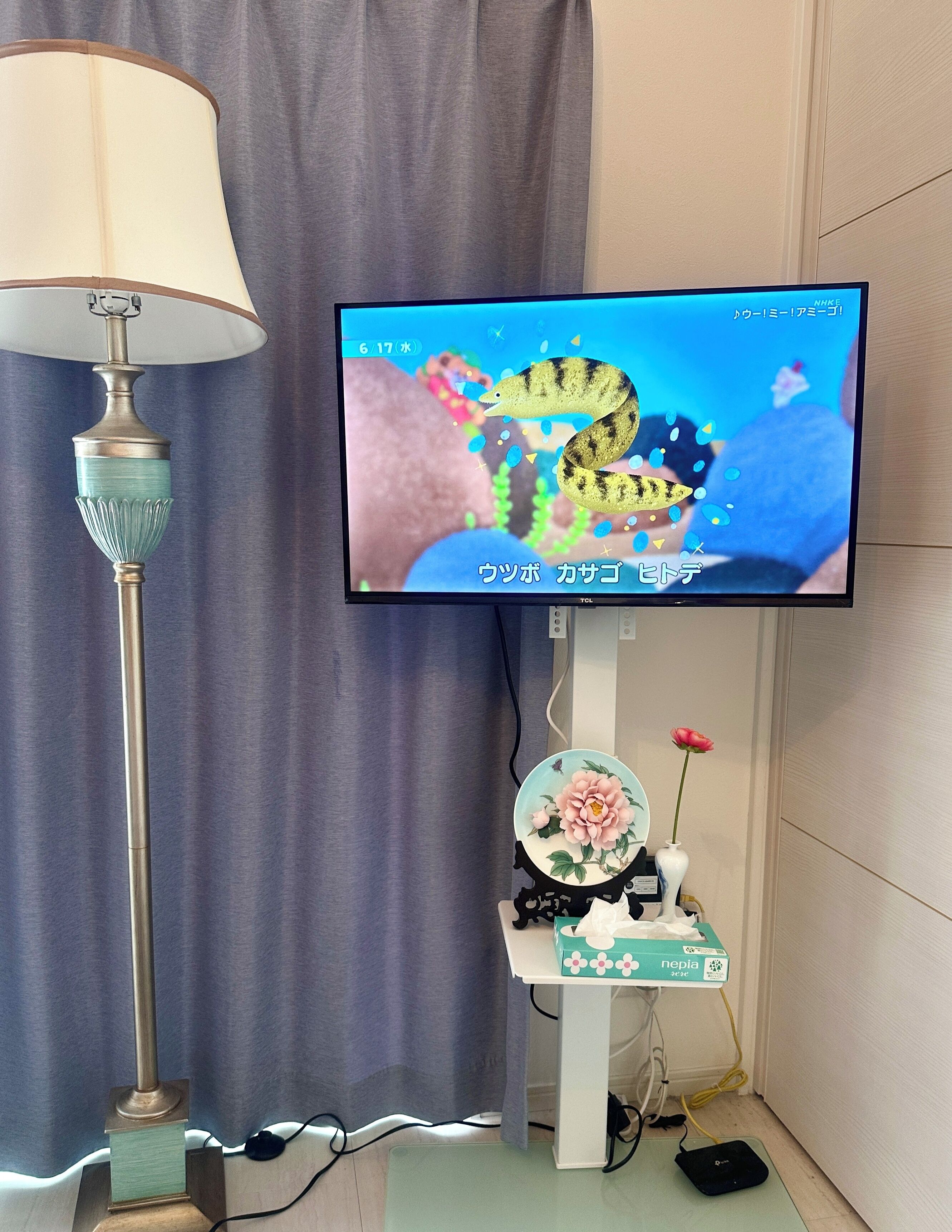 A television mounted on a wall with a decorative stand below it.