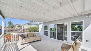 A covered patio area with a sofa and a chair, a potted plant, and a view of the backyard. - Pet-Friendly Home • Yard + Deck • Minutes to DT SD (Lemon Grove)