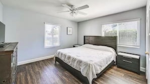 A bedroom with a bed, a nightstand, a dresser, and a ceiling fan. - Pet-Friendly Home • Yard + Deck • Minutes to DT SD (Lemon Grove)