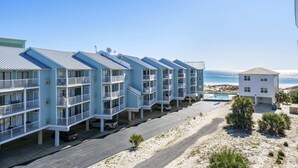 A beachfront hotel with multiple-story buildings, a swimming pool, and a beach view. - Sugar Beach 313 (Orange Beach)