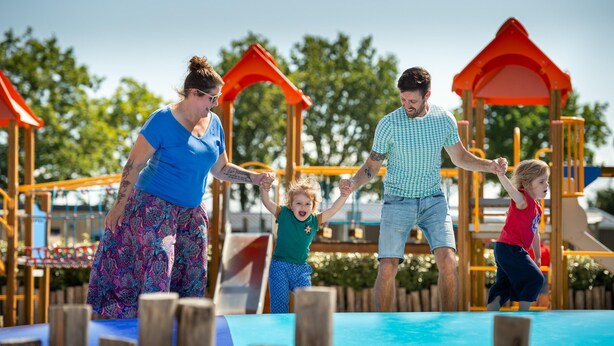 Ein Spielplatz mit Holzgerüsten und Rutschen.
