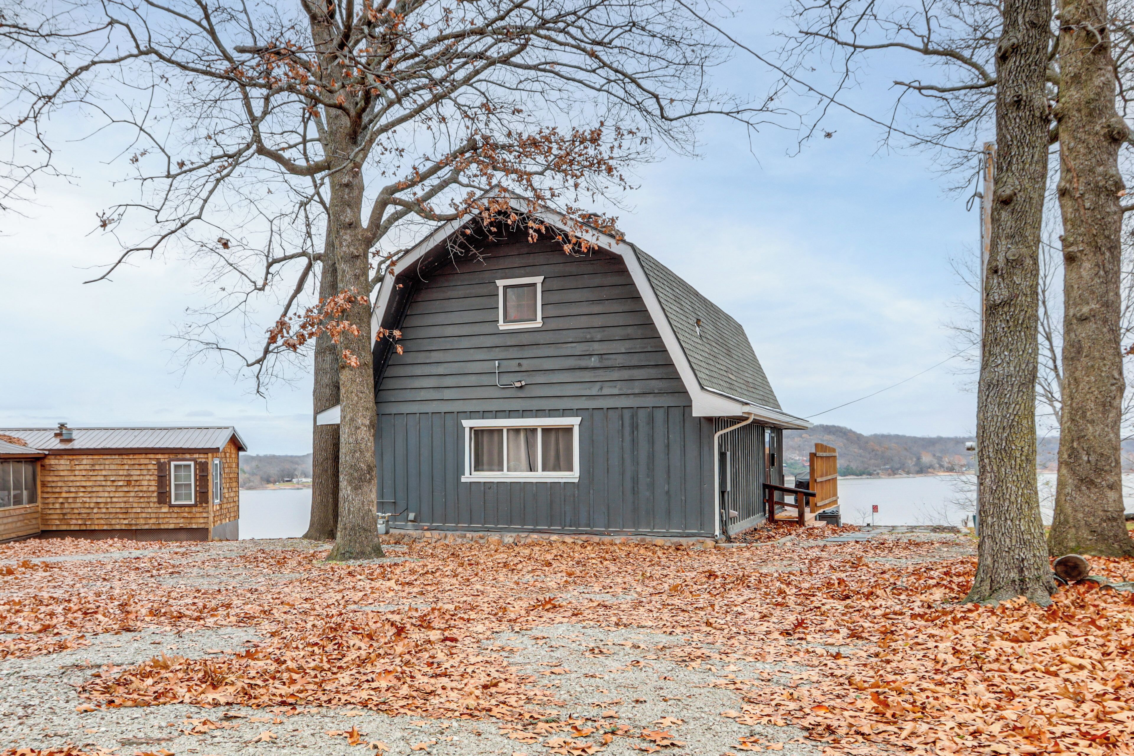 A rustic barn with a sloped roof, a small window, and a wooden door.