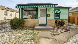 A single-story house with a green and white exterior, a front door, and a small porch with a green awning. - 2 Mi to Motor Speedway! Indy Home w/ Fenced Yard (Indianapolis)