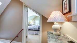 En gang med trappe, en seng i baggrunden og en lampe på en marmorplade.