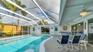 En inomhuspool med ett glastak, solstolar och utsikt över omgivningen.