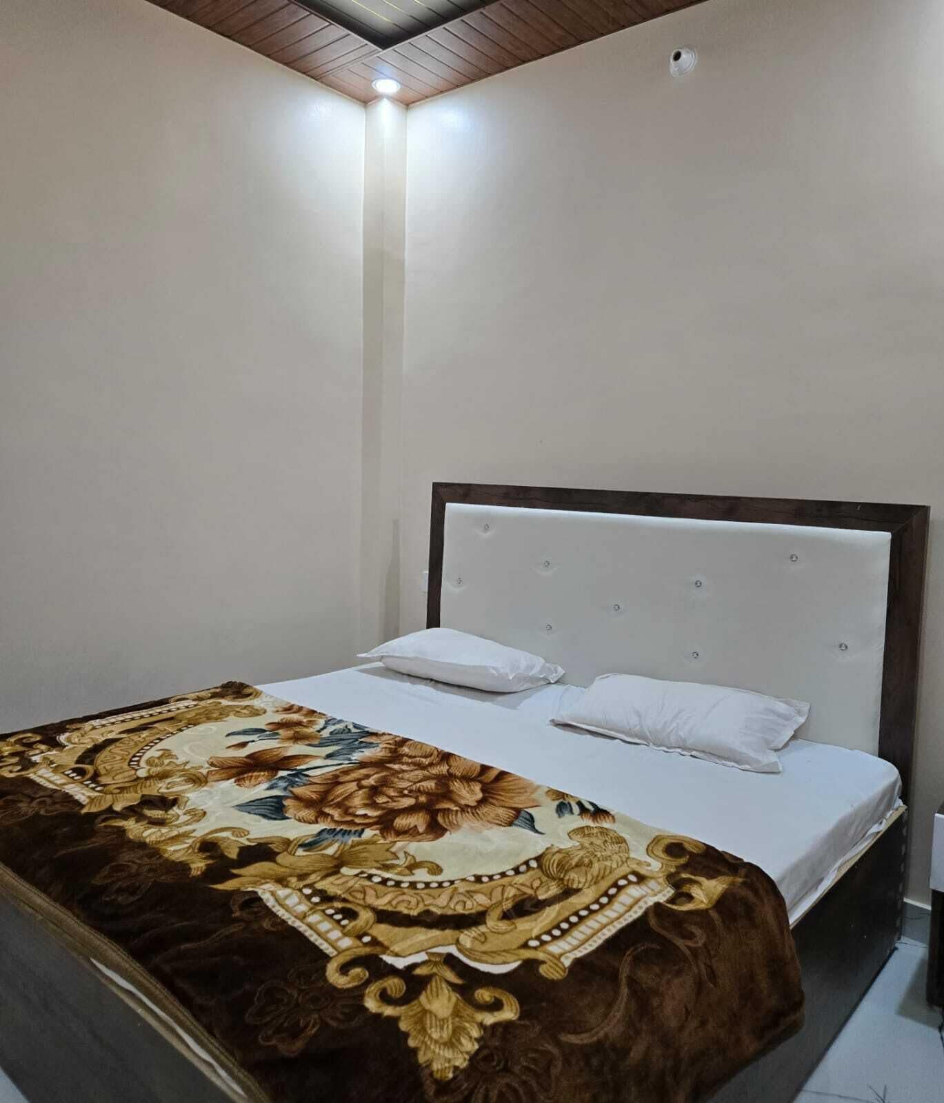 A bedroom with a bed, white bedding, and a decorative throw blanket.
