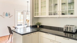 A kitchen with white cabinets, a black countertop, and a toaster. - Quiet Room + Great Location Near UW (Seattle)
