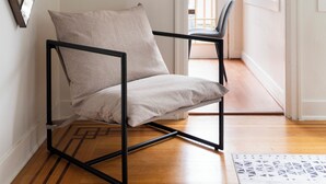 A modern room with a black metal chair, a beige cushion, a geometric mirror, and a patterned rug. - Quiet Room + Great Location Near UW (Seattle)
