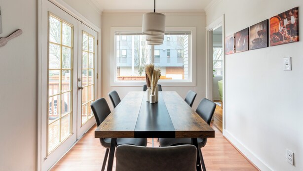 A dining area with a wooden table, black chairs, and a hanging light fixture. - Quiet Room + Great Location Near UW (Seattle)