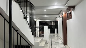 Eine Treppe mit schwarzen Geländern, die zu einer Zwischenebene führt.